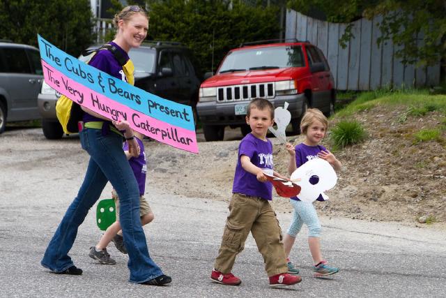 woman and several children walking in road