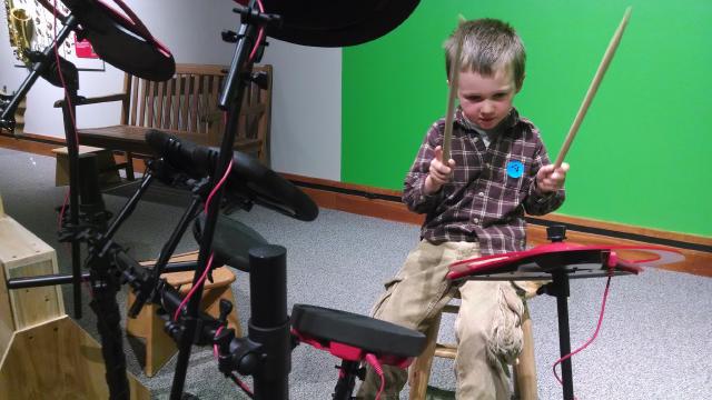 boy playing an electronic drum kit