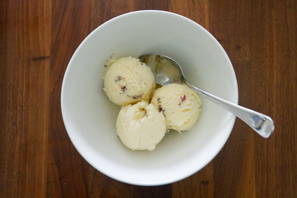 three scoops of ice cream and a spoon in a white bowl
