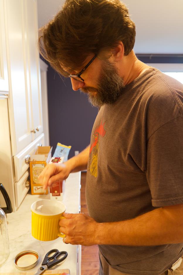Bearded man sprinkling something in large yellow mug