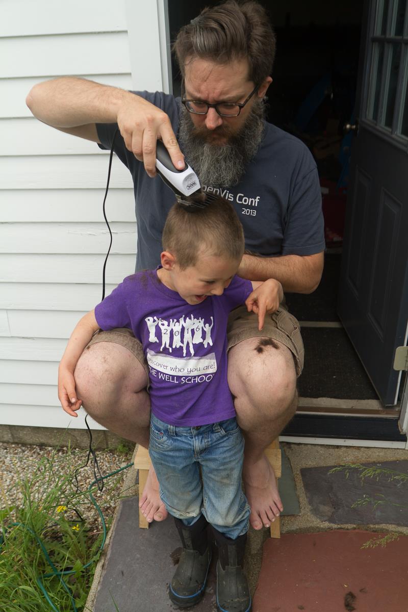 boy getting a buzz cut from a bearded man